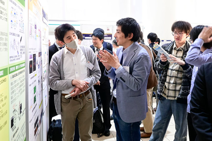 Participants discussing in front of posters