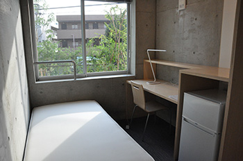 Individual rooms include beds, desks, and refrigerators, while kitchens, toilets, and showers are in common areas