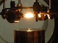 Fig. 2: Photograph of the apparatus showing the intense light resulting from heating the zirconia tube inside the vacuum chamber.