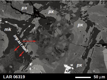 火星隕石に含まれる衝撃ガラス（赤矢印）の電子顕微鏡写真。