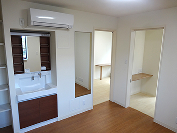 ユニット内共用部のリビングルームには洗面台や姿見、大きめのシューズボックスなどを設置