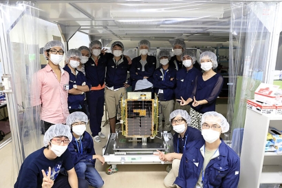 Members of the satellite development team with the TSUBAME flight model.