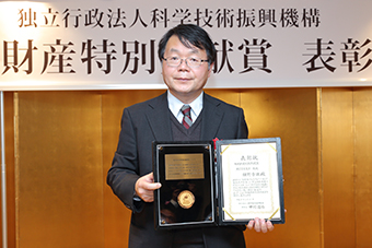 Hosono with the award certificate and medal