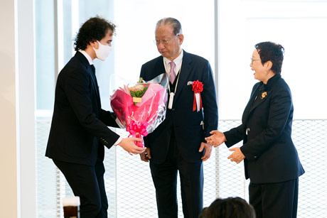 Student congratulating donors Hisao (center) and Hiroko (right) Taki 