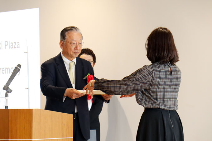 Alumnus Taki (left) presenting personal message to TPG leader Yanagase