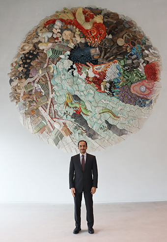 Ambassador Alfaheem in front of Taki Plaza's artistic centerpiece Elements of Future