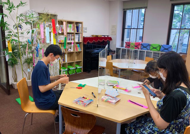 TA and participants writing wishes on tanzaku paper strips