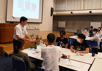 Prof. Ando (left) showing what happens when heat is applied to mouth of plastic bottle