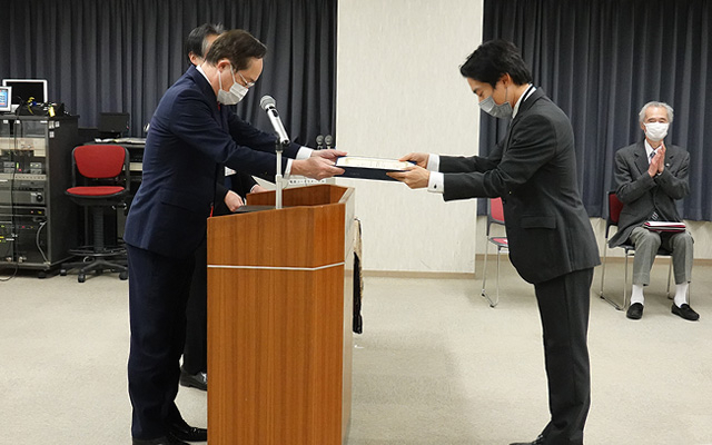 Recipient (right) receiving award from President Kazuya Masu