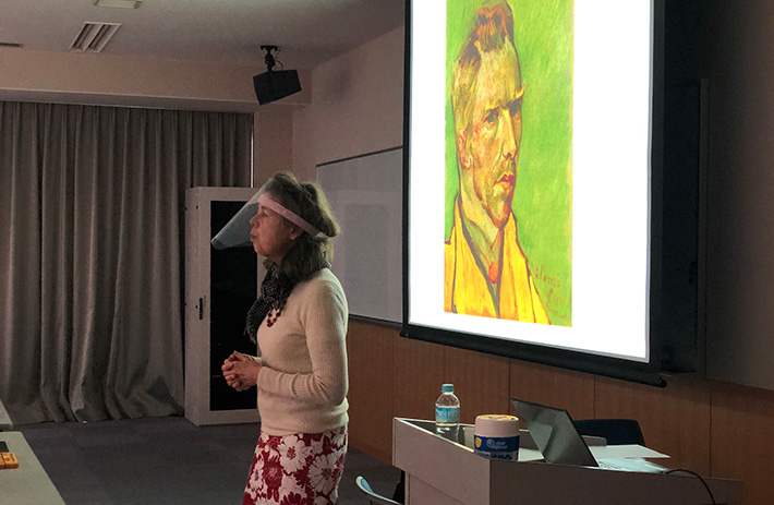 Meyer lecturing with van Gogh’s portrait in background