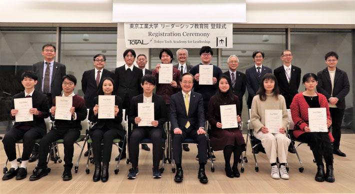 New students of December 2021 cohort, President Kazuya Masu (front, 4th from right), and ToTAL faculty at live registration ceremony at Hisao & Hiroko Taki Plaza (Taki Plaza)