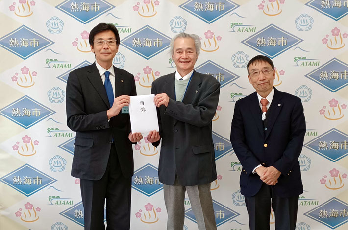 Executive Vice President Isao Satoh (center) and alumni association Secretary General Tadashi Tsujino (right) presenting donations to Atami City Mayor Sakae Saito