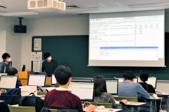 Students intensely focused on code demonstrated by instructor