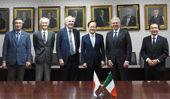 With flags of both countries (from left, Vice President Hayashi, Executive Vice President Sato, Counselor Traversa, President Masu, Ambassador Benedetti, and Executive Vice President Watanabe)