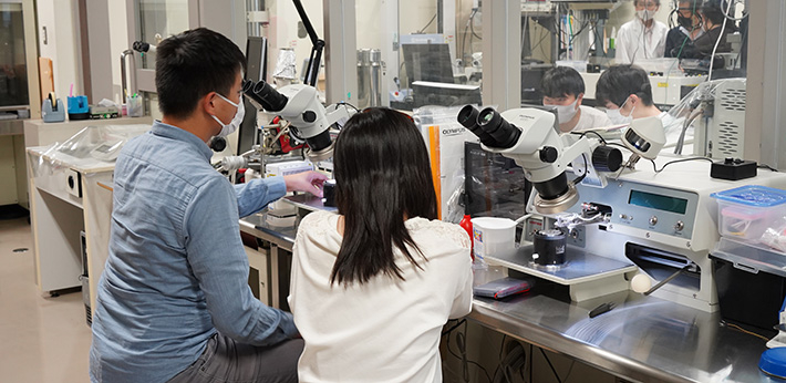 Jiang (left) explaining planned experiment to students in lab