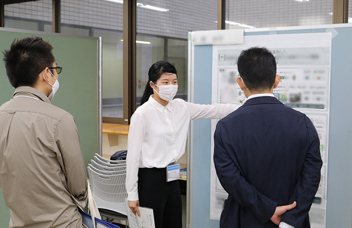 Students explaining poster content to audience members