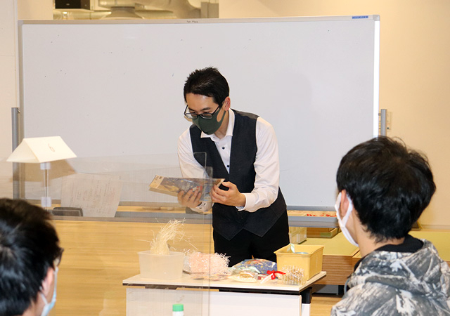 Koizumi demonstrating art of wrapping
