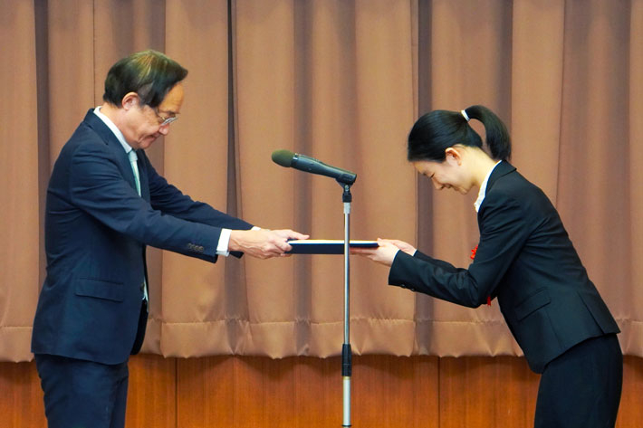 President Kazuya Masu (left) presenting the award to Asst. Prof. Youyou Cong