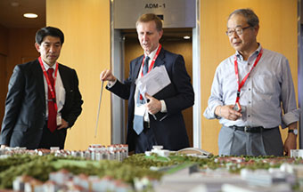 Professor White (center) displaying a model of NTU's campus