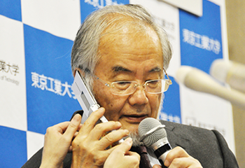 During the press conference, Ohsumi receives a congratulatory phone call from Prime Minister Shinzo Abe