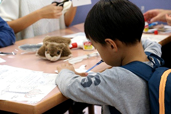 Younger generations testing out materials that high schoolers presented at their booths