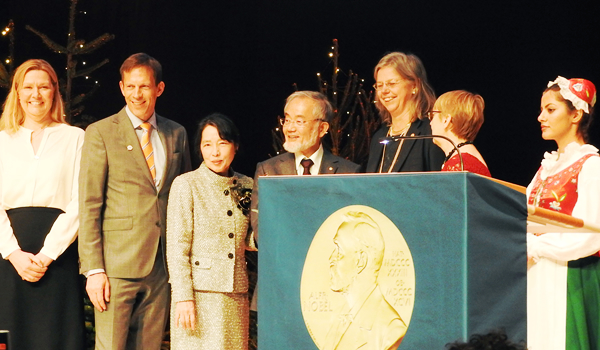 On stage with his wife and Nobel Foundation officials