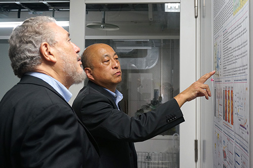 Professor Hara (right) explaining his labʼs research to Dr. Castro Diaz-Balart