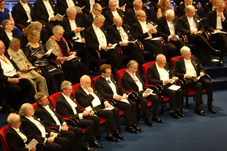 Noble laureates seated on the stage, Ohsumi third from right