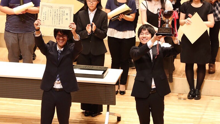 Overjoyed: President Kuhara with winners' certificate and Rehearsal Manager Ryohei Ito lifting trophy