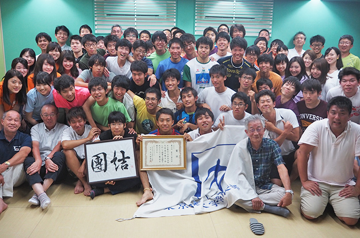 Rowing club members with congratulatory certificate