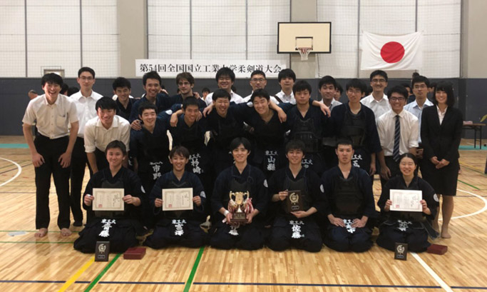 Ito (front row, third from left), Saito (front row, far left), and Kitahara (front row, far right) posing with other Kendo Club members after victory