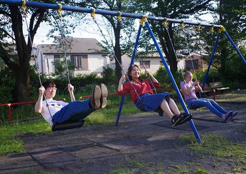 Participants enjoying the swings at the local park