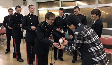 Tokyo Tech Judo Club member receiving wine from visitors