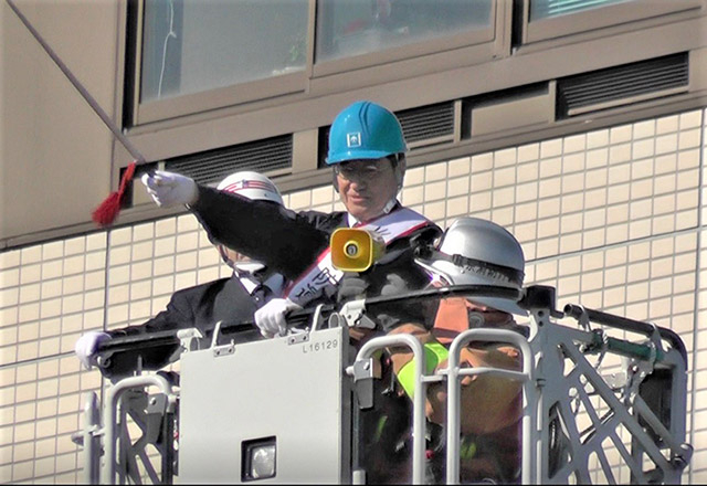 President Masu initiating water discharge by fire department