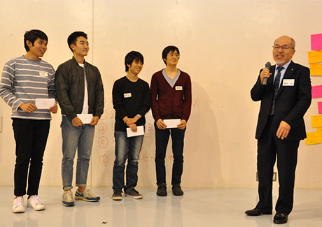 Gurunavi, Inc. Executive Vice President Hisao Iizuka (right) congratulating Team √3 for earning the Gurunavi Award