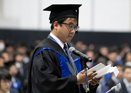 Yushi Yoshitake delivering valedictory at master's and doctoral degree graduation ceremony