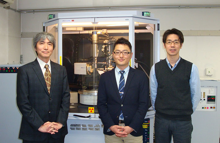 Yoshihisa Sei (left), Masahiro Yamashina (center), and Michito Yoshizawa (right) in front of X-ray diffractometer for crystallographic analysis.