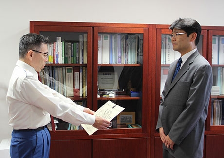 Denenchofu Fire Station Chief Katsuhiro Miyakawa (left) commending Kudo