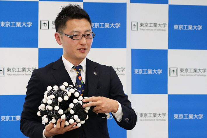 Assistant Professor Masahiro Yamashina using a molecular model