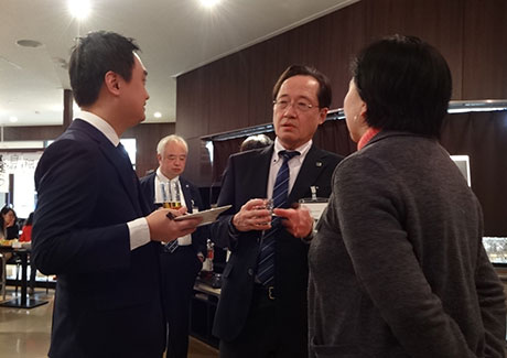 Masu (center) talking with attendee