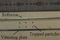 Small particles levitated between a vibrating plate and a reflector using ultrasound.