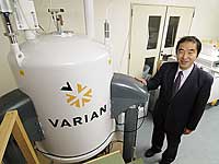 Hirai poses beside his center's MRI system.