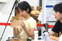 Student carefully inspecting a piece of cardboard