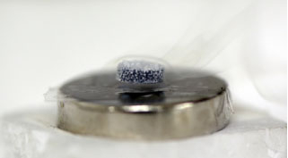 A superconductor is floating above a permanent magnet