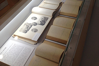 Well-bound notebooks on display (left), images of notebooks projected onto Museum wall (right)