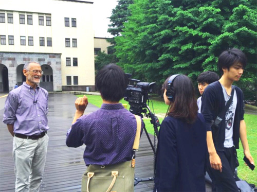 Professor Stewart recording a video segment in front of the Main Building