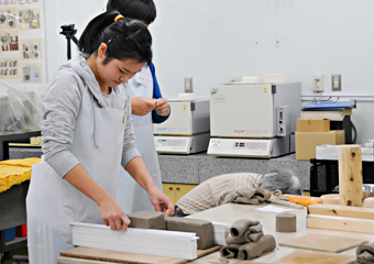 Slicing a block of clay to prepare individual clay slabs for hand building