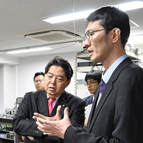 Kozuma answering questions from then minister Yoshimasa Hayashi