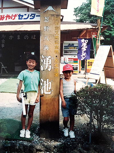 Prof. Yamazaki (left) going camping in summer, carrying his favorite telescope.