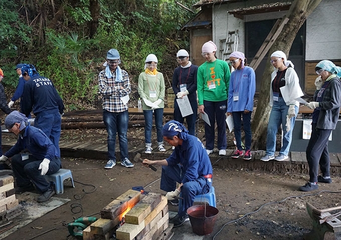 Students observe as Master Swordsmith Matsuda forges steel